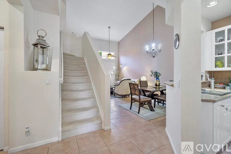 A living room with a staircase and a dining table.
