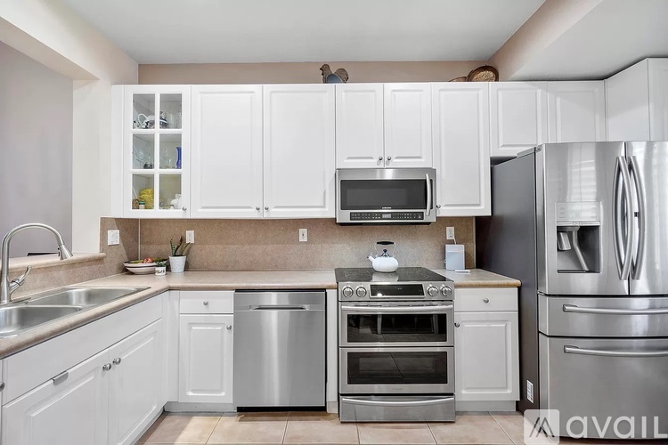 A kitchen with white cabinets and stainless steel appliances.