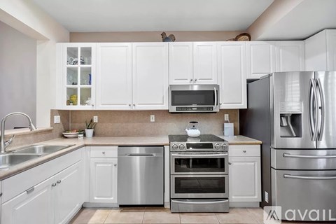 A kitchen with white cabinets and stainless steel appliances.