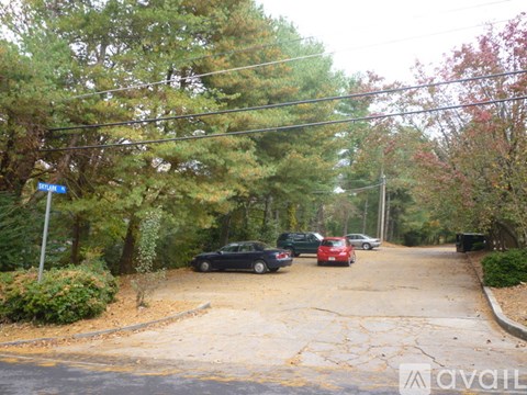 A street with cars parked on the side and a sign that says "Avail".