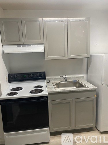 A kitchen with a white stove and a white sink.