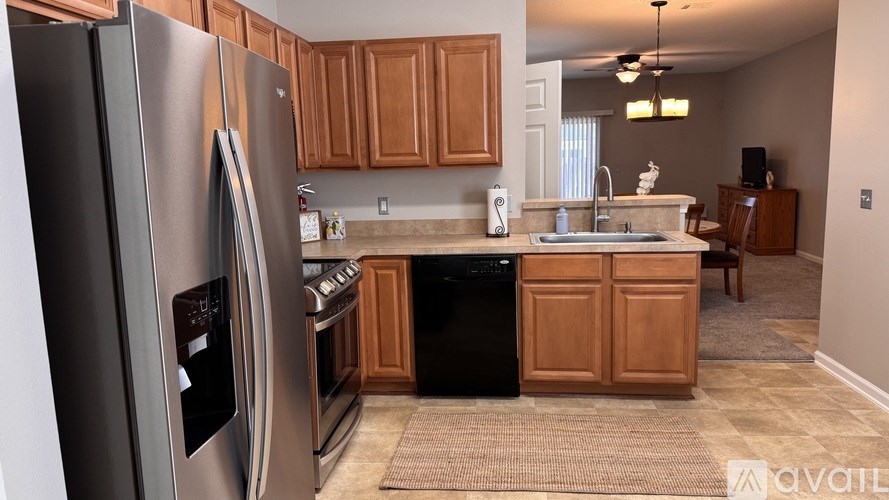 A kitchen with wooden cabinets and a stainless steel refrigerator.