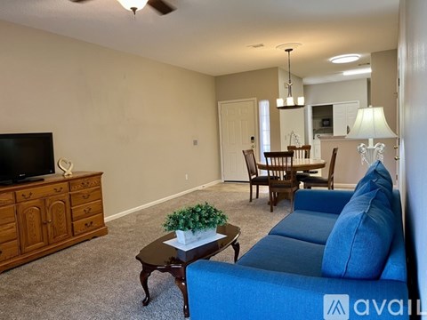 A living room with a blue couch and a wooden cabinet.