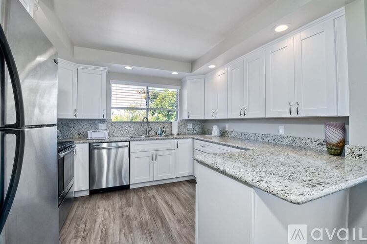 A kitchen with white cabinets and a granite countertop.