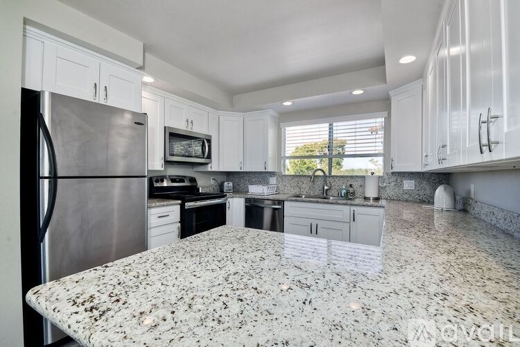 A kitchen with granite countertops and stainless steel appliances.