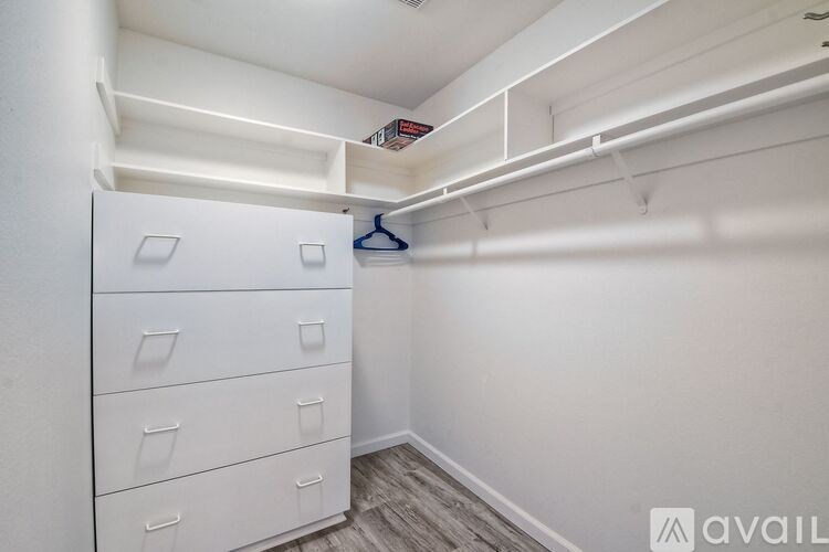 A white closet with drawers and a hanging shelf.