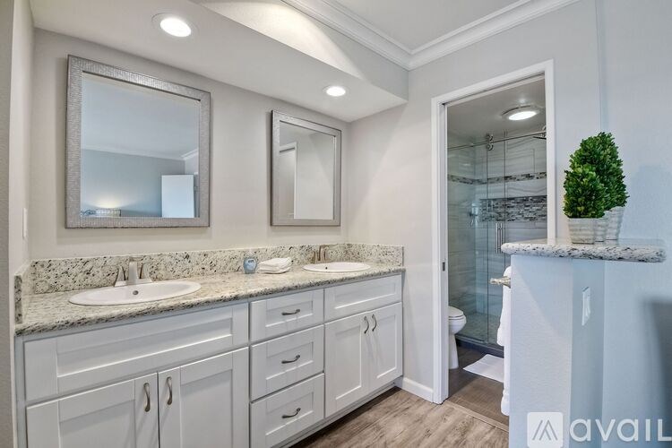 A bathroom with a marble countertop and a large mirror above the sink.