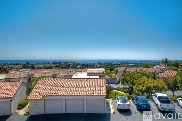 A row of houses with cars parked in front.