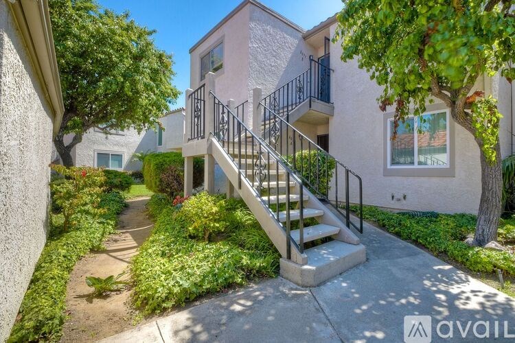 A sunny day at a residential area with a house and a tree.
