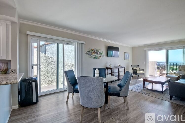 A modern dining room with a table set for four and a view of the outdoors.