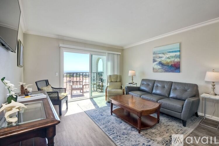 A living room with a leather couch, a wooden coffee table, and a painting on the wall.