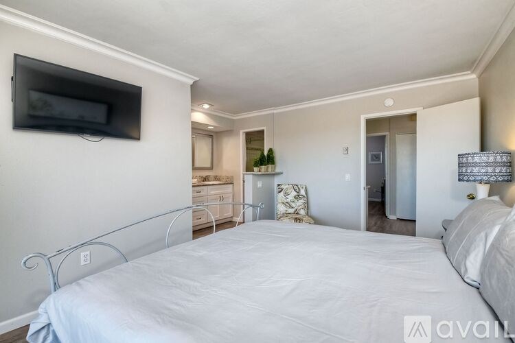 A bedroom with a bed, dresser, and television.