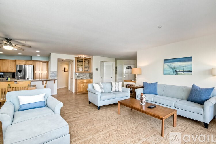 A living room with a grey couch, a wooden coffee table, and a painting on the wall.