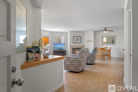 A living room with a grey couch, a wooden coffee table, and a painting on the wall.