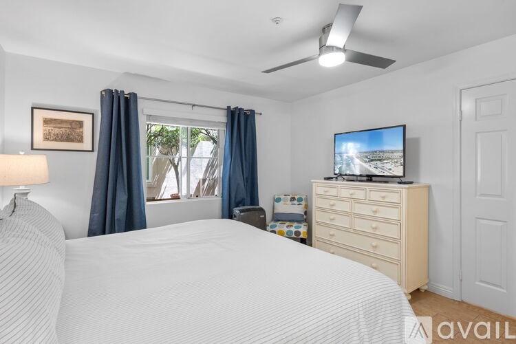 A patio with a table and chairs overlooks a row of apartment buildings.