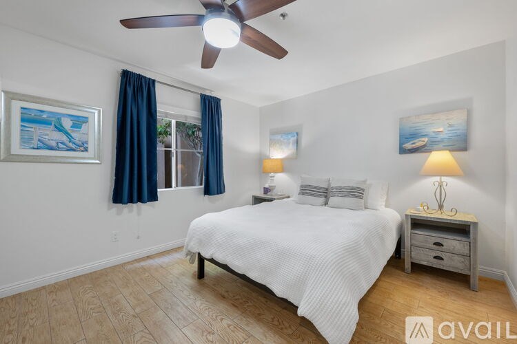 A long pier extends into the water under a blue sky.