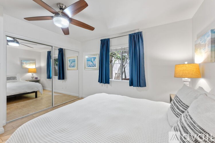 A sign that says Oceanside Pier stands in front of palm trees.