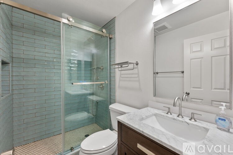 A bathroom with a glass shower door and a white toilet.