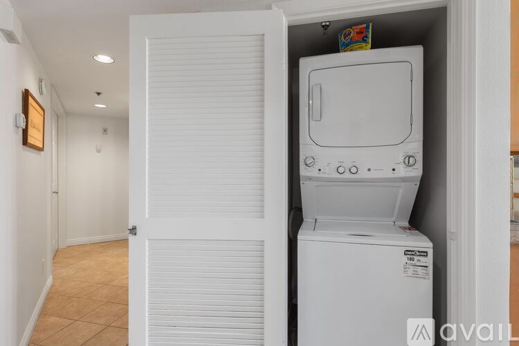 A white washing machine is in a small closet.