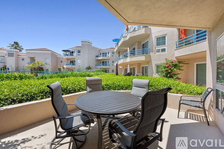 A patio with a table and chairs overlooks apartment buildings.
