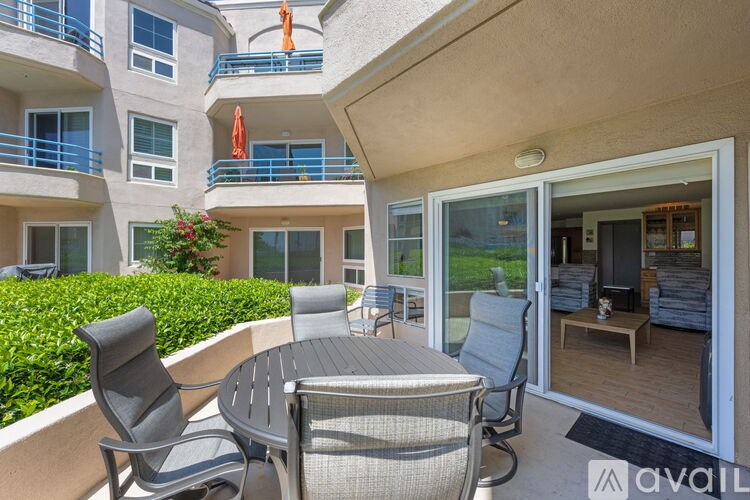 A patio with a table and chairs is shown with a building in the background.