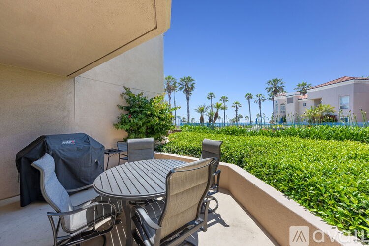 A patio with a table and chairs overlooking a garden.