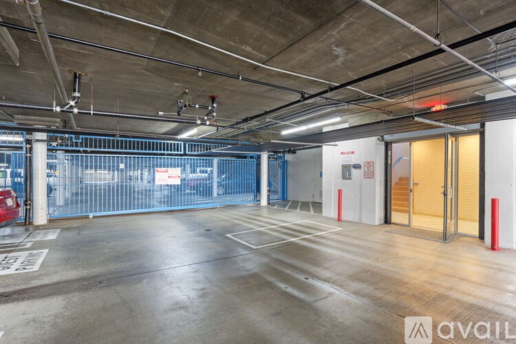 A large, empty parking garage with a red car parked in the foreground.