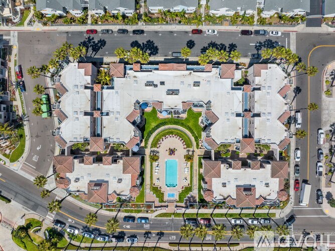 An aerial view of a residential complex with a swimming pool in the center.