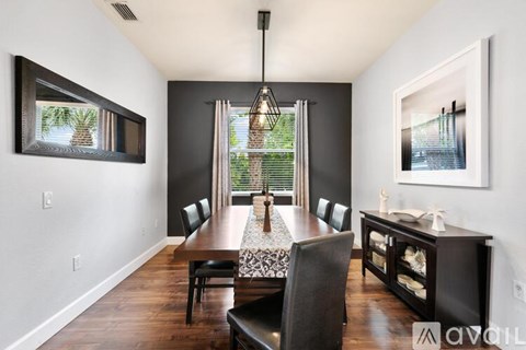 A dining room with a wooden table and chairs.