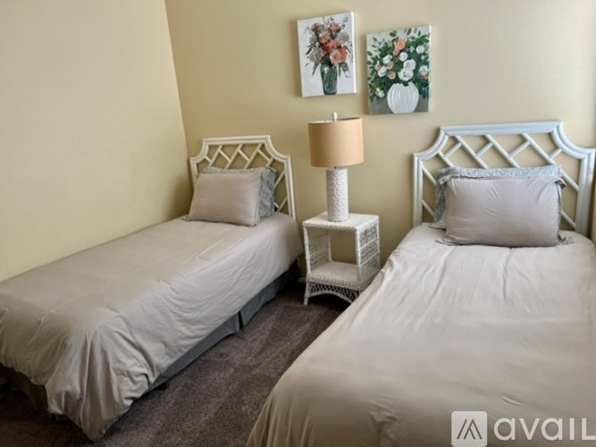 Two twin beds with white headboards and pillows in a room.