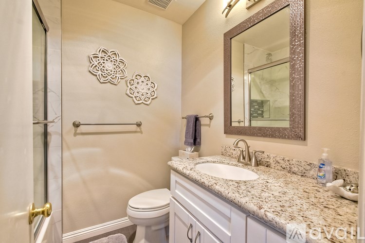 A bathroom with a toilet, sink, and mirror.