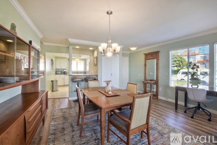 A dining room with a wooden table and chairs.