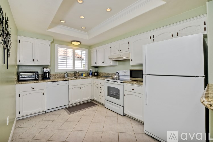 A kitchen with white appliances and cabinets.