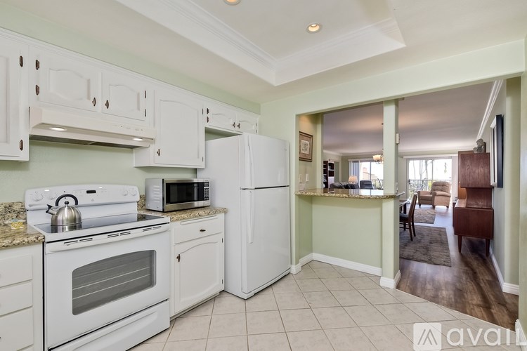 A kitchen with white appliances and cabinets.