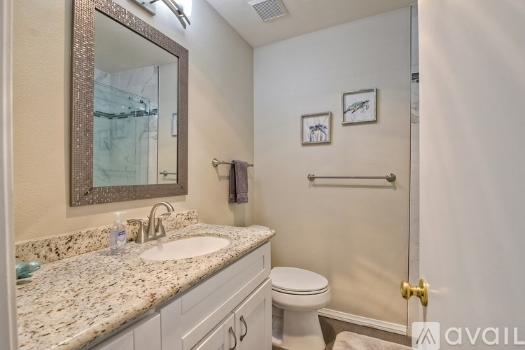 A bathroom with a marble countertop and a large mirror.