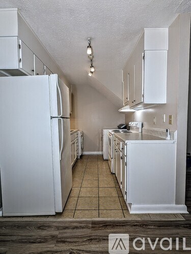 A kitchen with white appliances and cabinets.