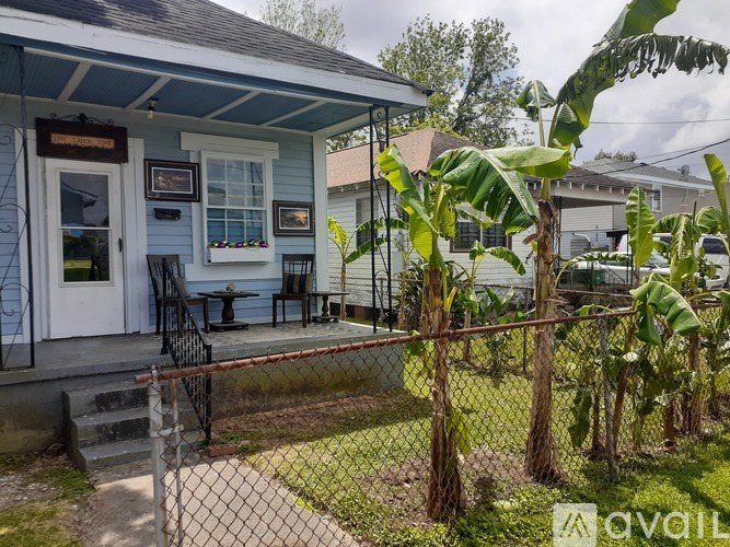 A blue house with a porch and a fence.