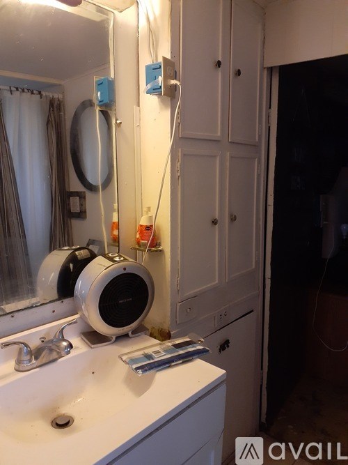 A bathroom with a sink, mirror, and a shower curtain.