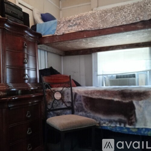 A brown wooden dresser with a bunk bed on top of it.