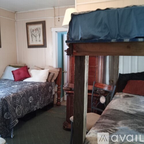 A bedroom with two beds and a chair.