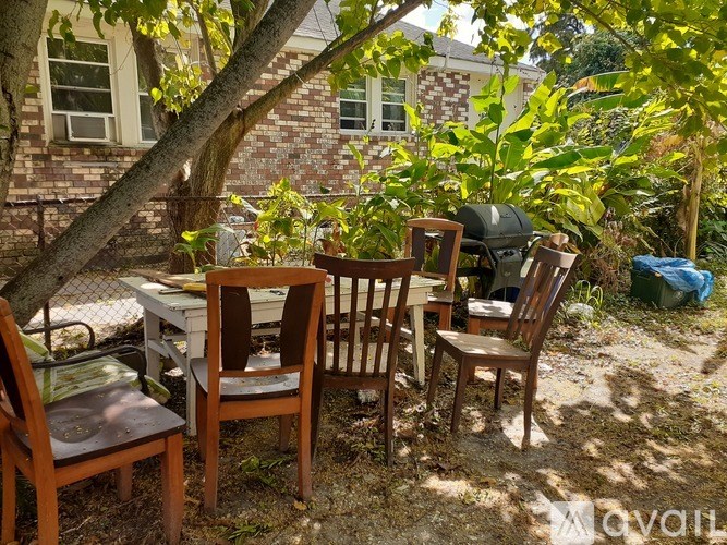 A table with chairs is set up in a backyard.