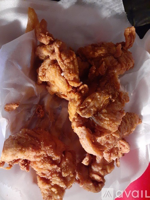 Fried chicken strips on a white paper.