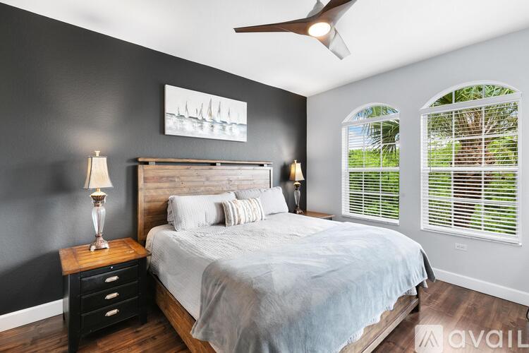 A bedroom with a bed, nightstand, and a ceiling fan.