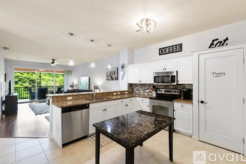 A kitchen with a black table and a coffee sign on the wall.
