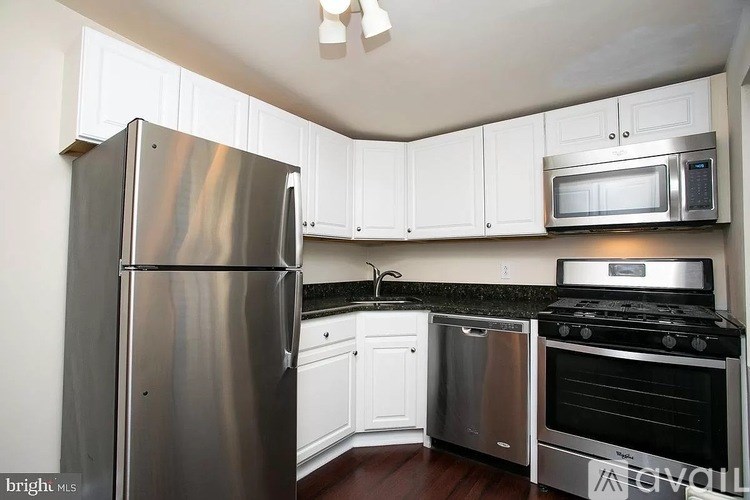 A kitchen with a stainless steel refrigerator, oven, and microwave.