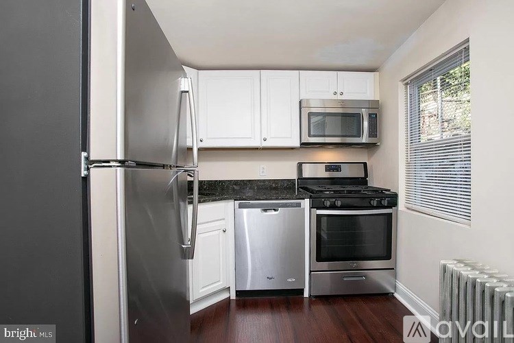 A kitchen with a stainless steel refrigerator, microwave, dishwasher, and oven.