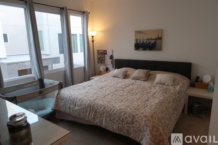 A bedroom with a large bed and a window overlooking a cityscape.