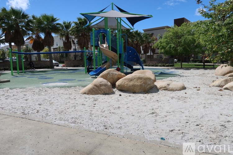 A playground with a blue and white slide and a green canopy.
