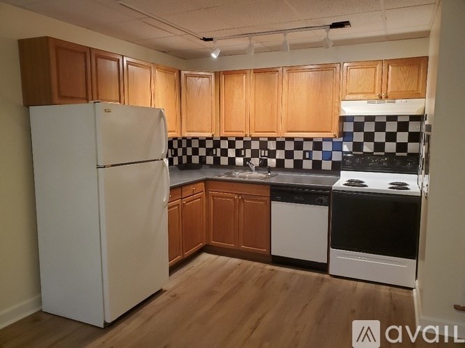 A kitchen with wooden cabinets and a white refrigerator.