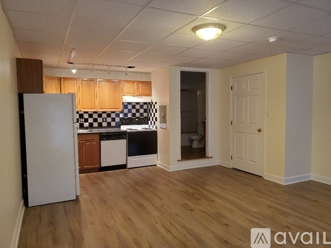 A kitchen with a white refrigerator and wooden cabinets.